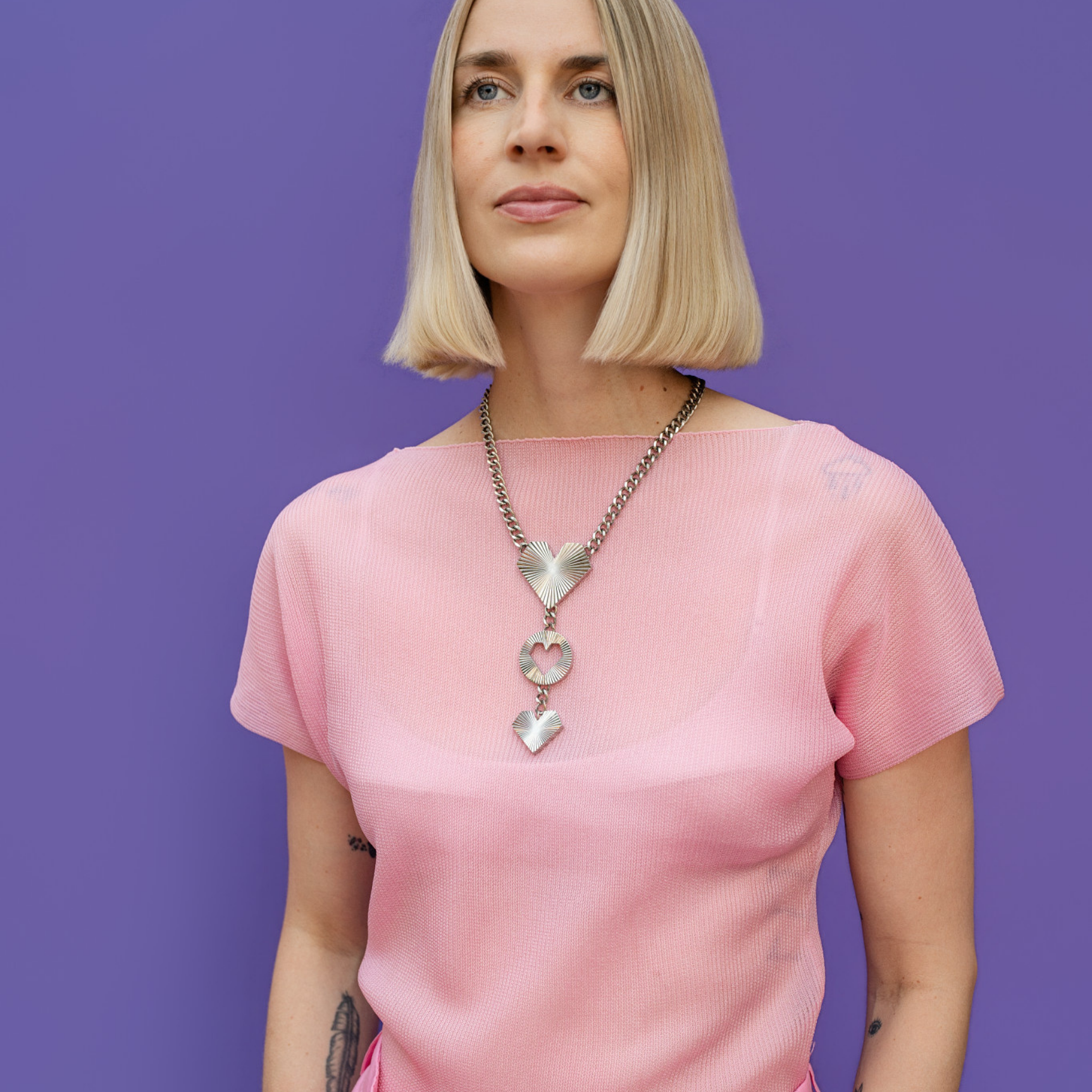 Frau trägt Heartcore Statement Kette in silber von schmucktick aus Edelstahl mit drei Herzanhängern und Sunburst-Finish