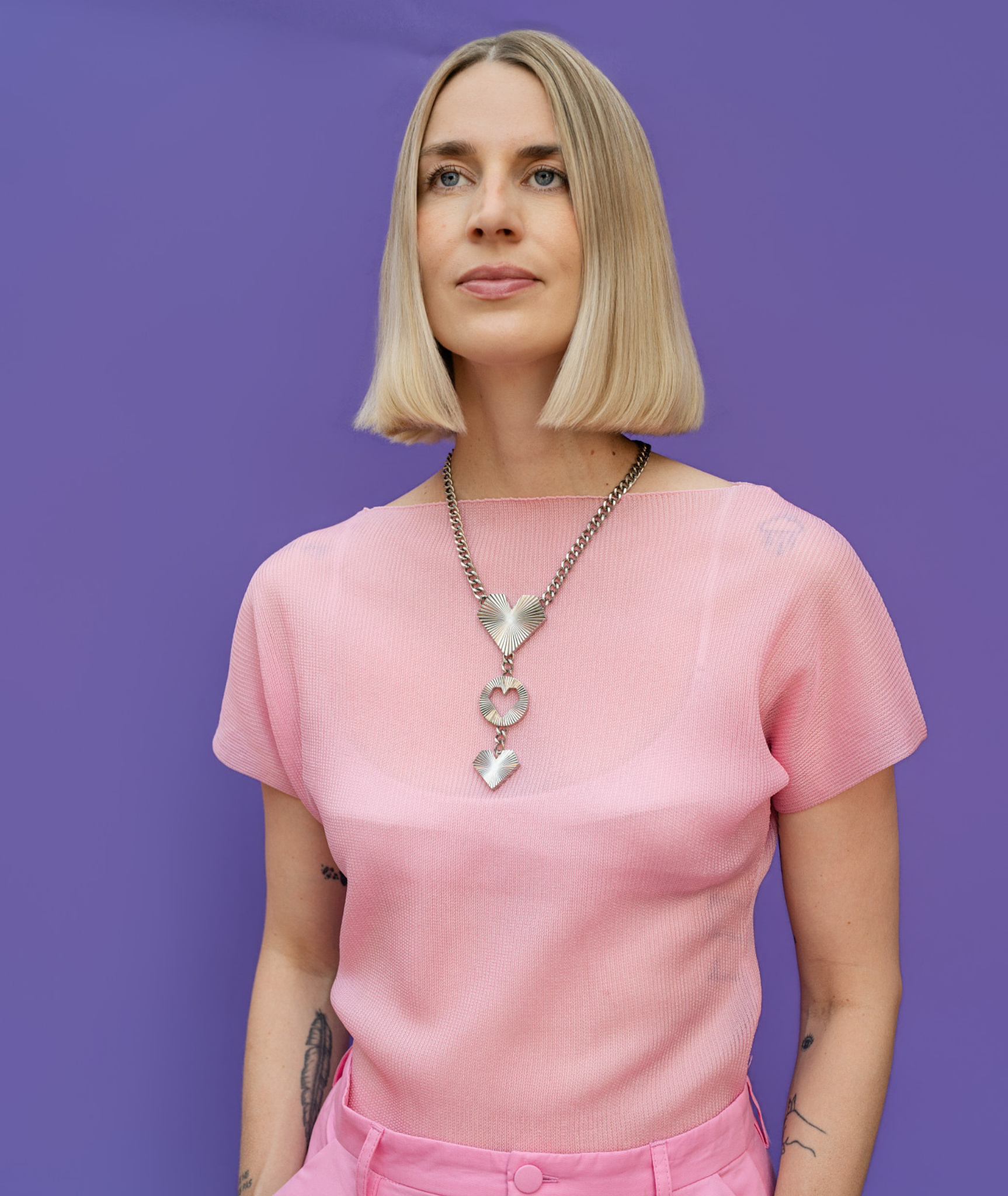 Frau trägt Heartcore Statement Kette in silber von schmucktick aus Edelstahl mit drei Herzanhängern und Sunburst-Finish