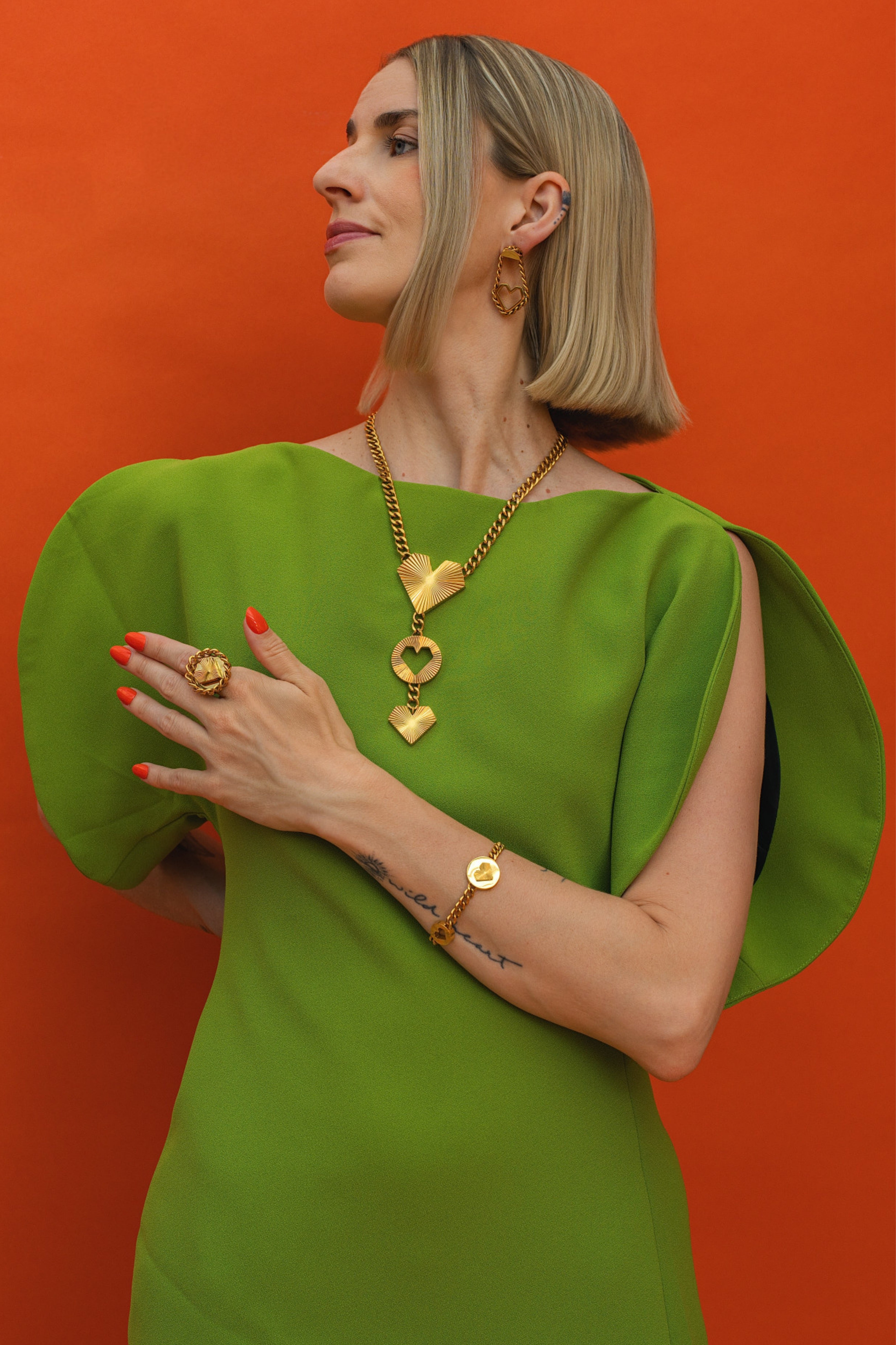 Frau trägt goldene HEARTCORE Kette und Ring und Ohrringe mit Herz von schmucktick